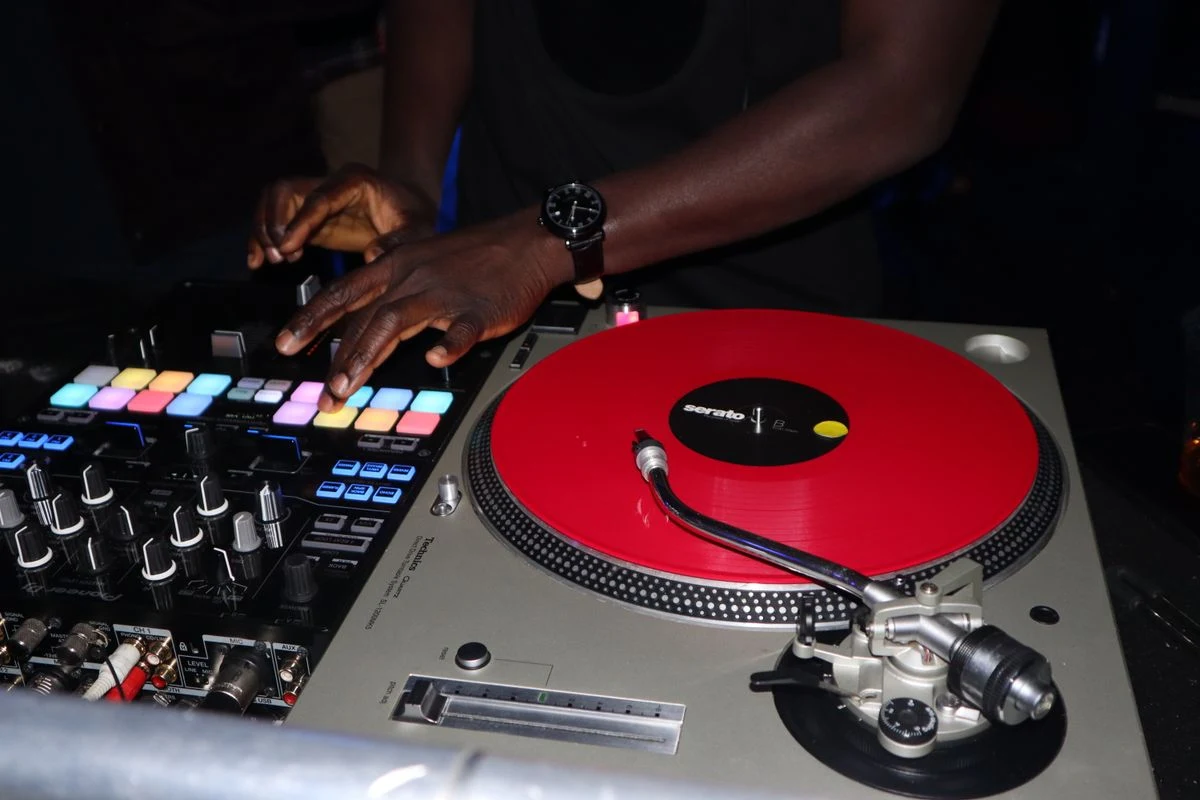 A DJ working with turntables and a mixer.