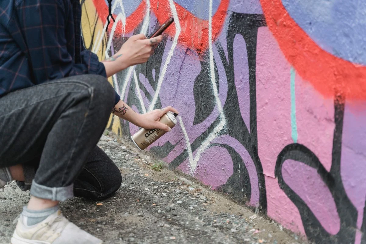 An artist painting a graffiti piece.