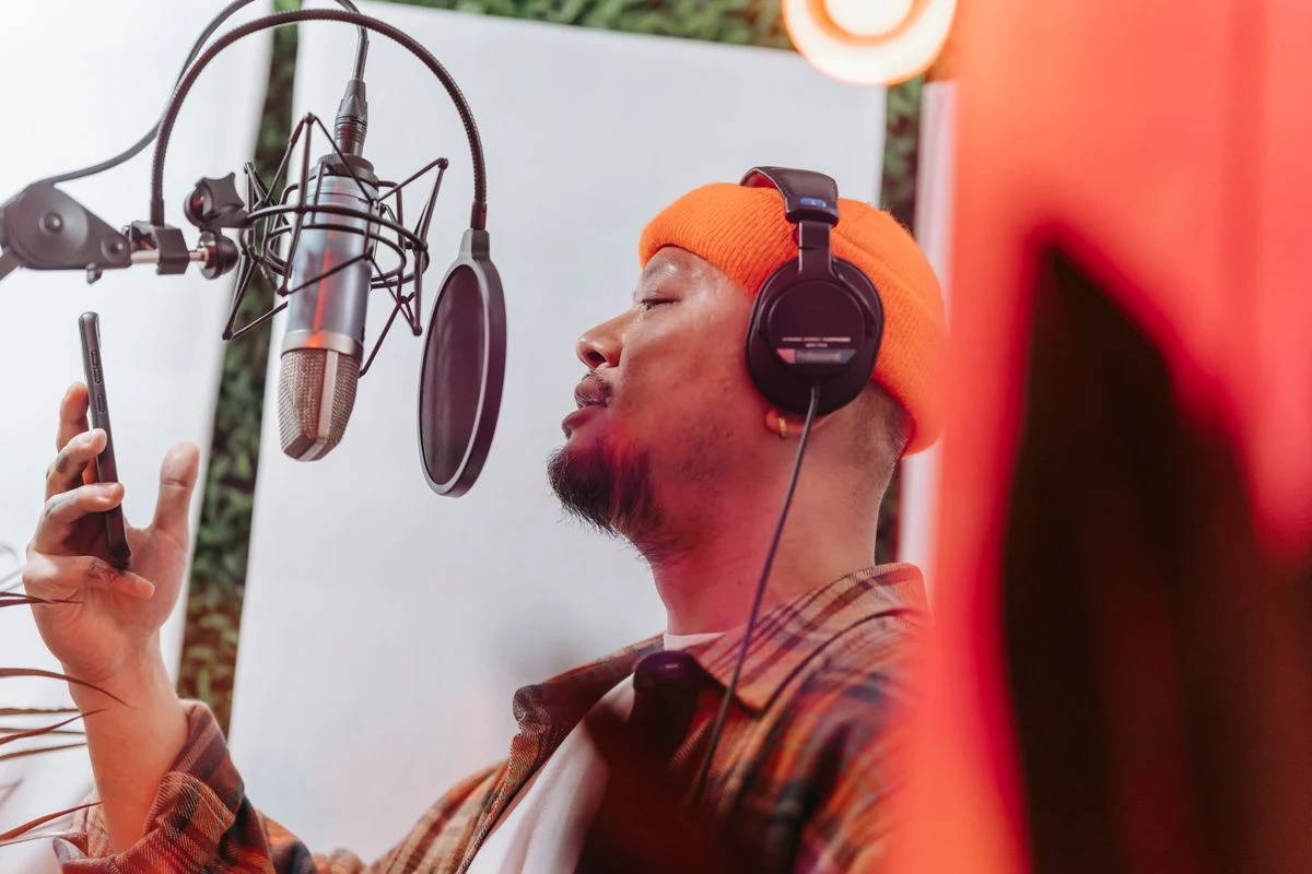 A vocalist recording at a studio microphone.